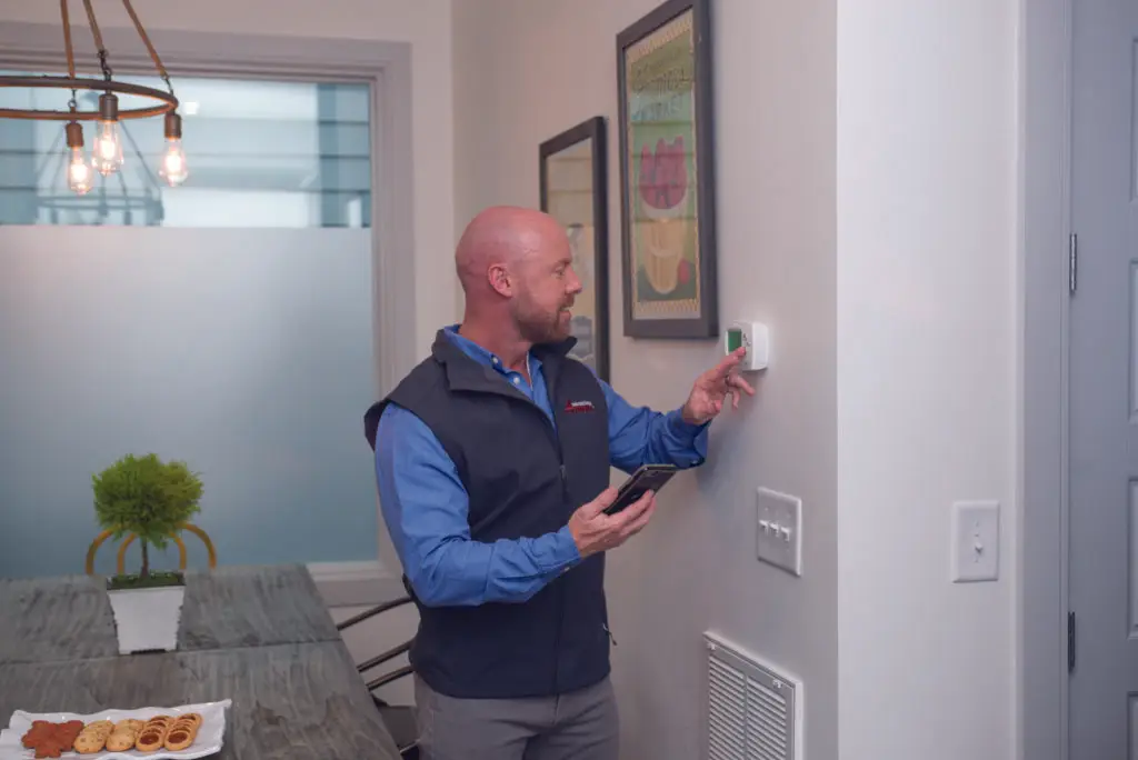 All Valley Air dealer adjusting a thermostat